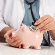 An Image of a Doctor Using a Stethoscope on a Piggy Bank Put On By Secure Money Advisors In Pittsburgh