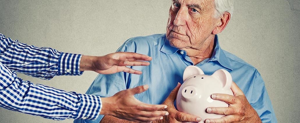 An Image of a Retired Man Not Wanting to Let Go of a Piggy Bank Put On By Secure Money Advisors In Pittsburgh