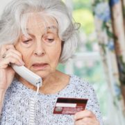 An Image of a Retired Women On the Phone While Holding a Credit Card Put On By Secure Money Advisors In Pittsburgh