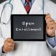 An Image Of A Doctor Holding Up A Sign For Open Enrollment To Represent Medicare Fall Open Enrollment Put On By Secure Money Advisors In Pittsburgh
