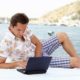 An Image Of A Young Man Sitting On A Boat While Working On His Laptop And Investing In Things To Produce Financial Freedom Put On By Secure Money Advisors In Pittsburgh