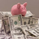 An Image Of A Piggy Bank Sitting On Top Of A Stack Of Hundred Dollar Bills Put On By Secure Money Advisors In Pittsburgh