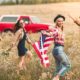 An Image Of Two Young Couples Holding An American Flag And Walking Through A Field Put On By Secure Money Advisors In Pittsburgh