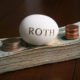 An Image Of A Roth Egg On Top Of Coins And Cash For The Roth IRA 5 Year Rule Put On By Secure Money Advisors In Pittsburgh