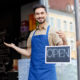 An Image Of A Man Holding An Open Sign For His Small Business Put On By Secure Money Advisors In Pittsburgh