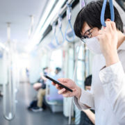 An Image Of A Man Wearing A Mask On A Train Looking At His Phone Put On By Secure Money Advisors In Pittsburgh