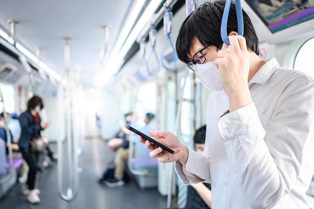 An Image Of A Man Wearing A Mask On A Train Looking At His Phone Put On By Secure Money Advisors In Pittsburgh